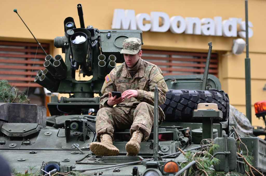 Soldier on tank in front of McDonalds